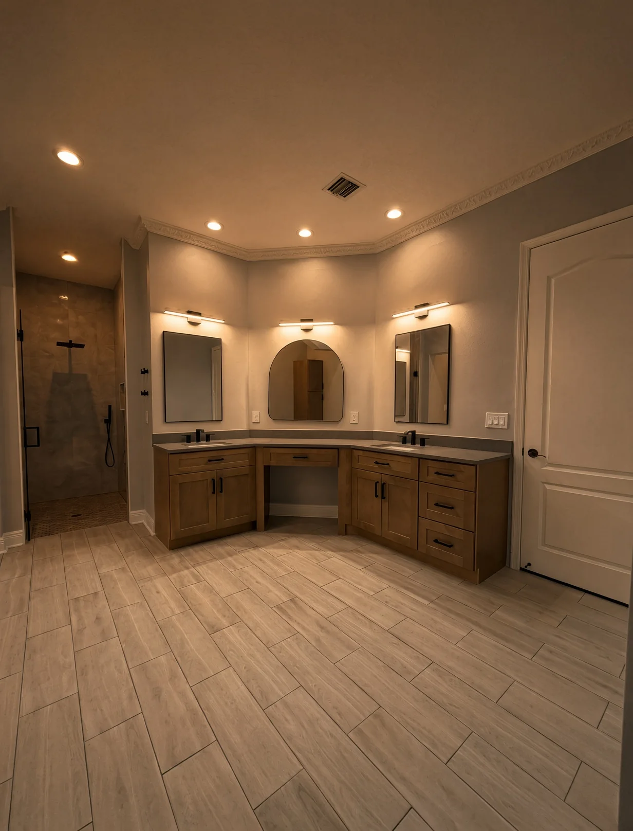 Bathroom with a wood double vanity, arched mirror and walk-in shower in warm light