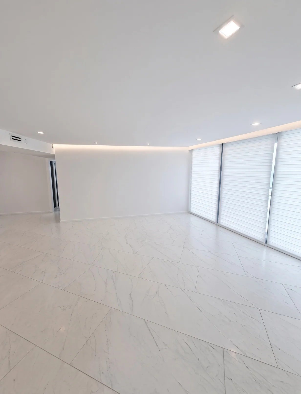 Living room with marble-look tile, recessed lighting and floor-to-ceiling windows
