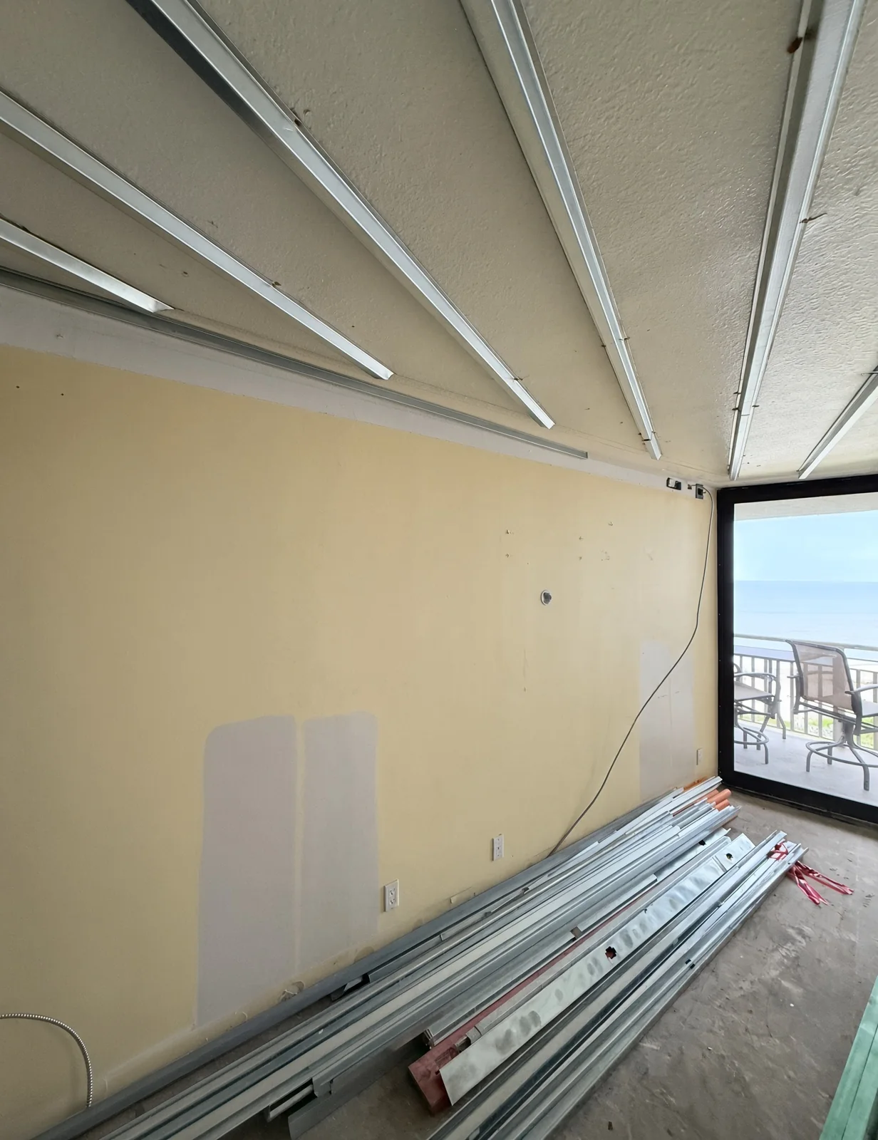 Metal ceiling framing going in beside an ocean-view balcony door