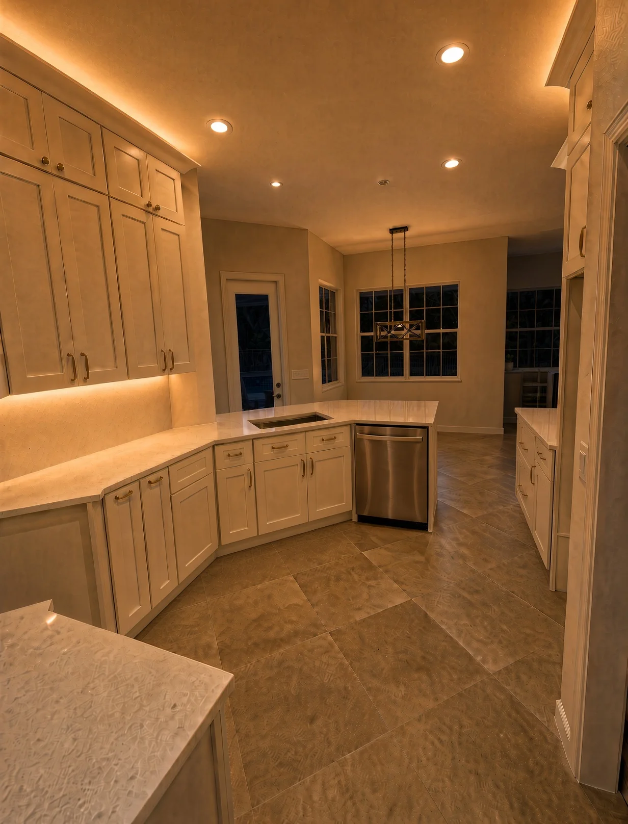 White shaker kitchen in the evening with crown and under-cabinet lighting