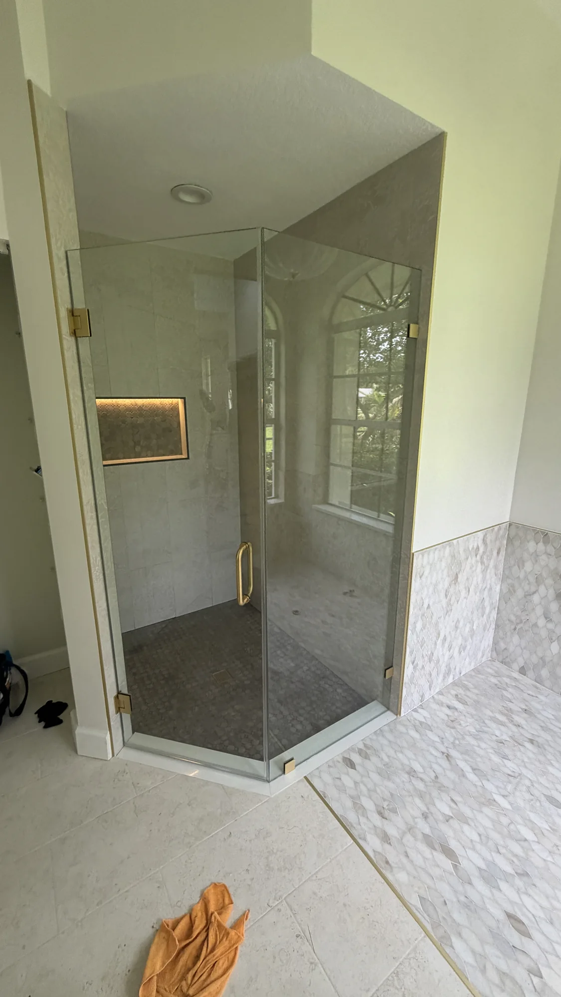 Glass shower and tile work before cleanup