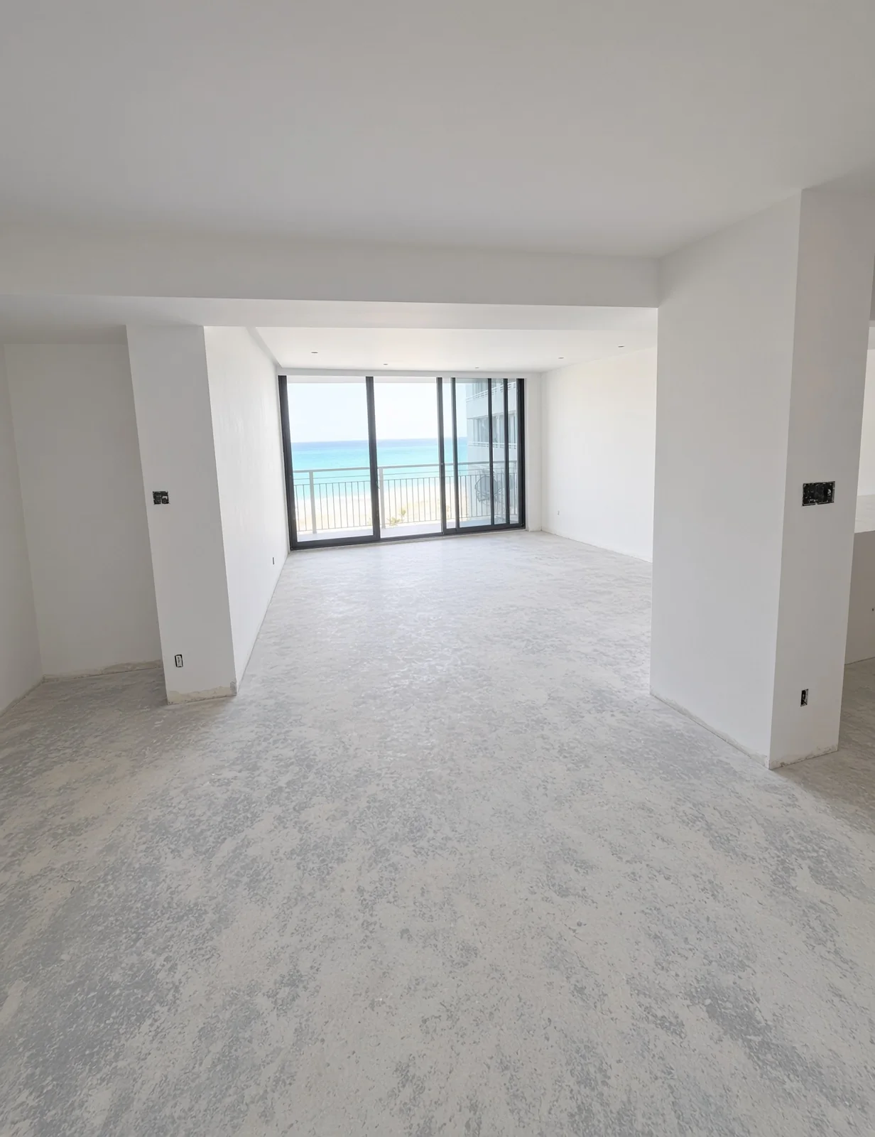 Empty unit with a skim-coated floor ready for tile